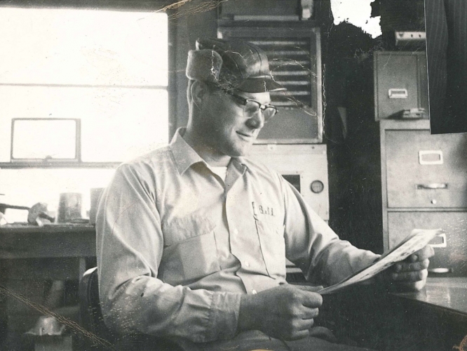 Bill Merschman, our Founder, sitting at a desk.